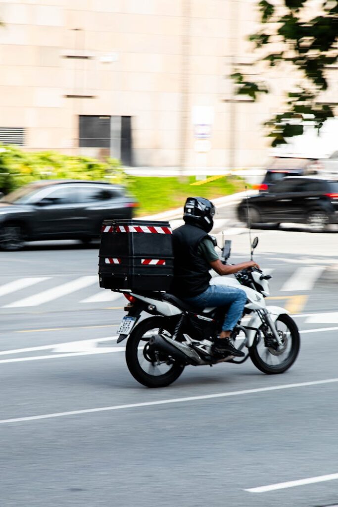 Motorcyclist delivers packages swiftly through busy city streets.